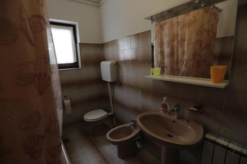 a small bathroom with a sink and a toilet at Apartman Ljubica in Punat