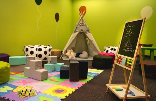a childs room with a play area with a play tent at Leonardo Hotel Weimar in Weimar