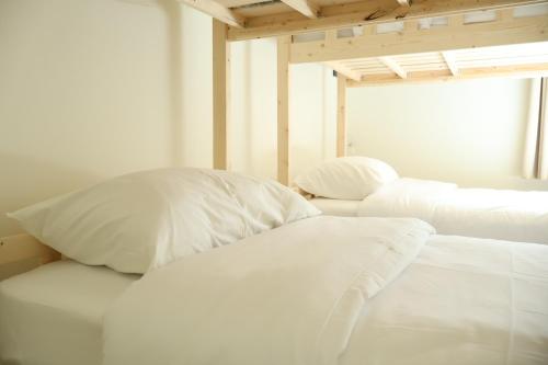two white pillows sitting on a bed in a room at Ilik House ไอลิกเฮ้าส์ in Hat Yai