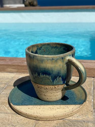 a coffee cup sitting on a saucer next to a pool at Boutique Hotel Luz da Lua in Ponta do Sol