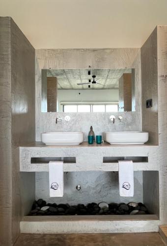 a bathroom with two sinks and two mirrors at Boutique Hotel Luz da Lua in Ponta do Sol