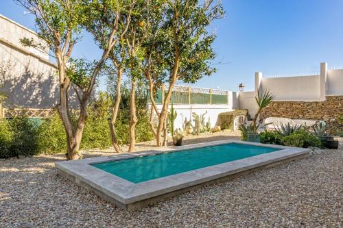 - une piscine dans une cour arborée et un bâtiment dans l'établissement Villa sur la plage Cap Corse, à Brando