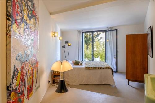 ein Schlafzimmer mit einem Bett und einem großen Fenster in der Unterkunft Villa sur la plage Cap Corse in Brando