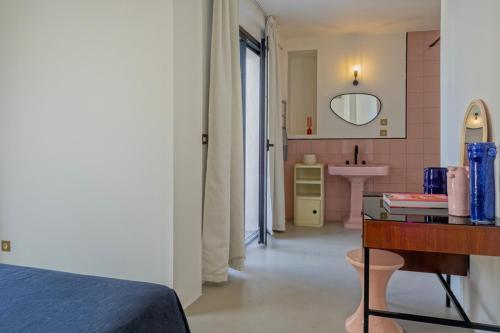 ein Schlafzimmer mit Bett und ein Badezimmer mit Waschbecken in der Unterkunft Villa sur la plage Cap Corse in Brando