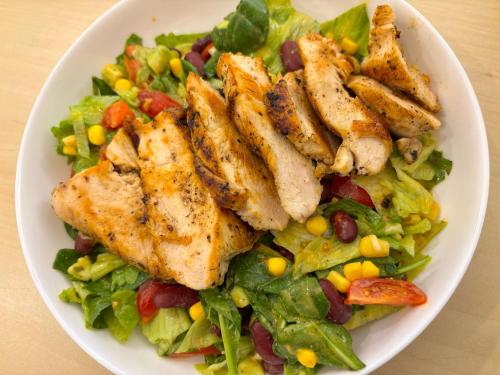 a plate of food with chicken and a salad at Pensiunea Casa Weiss in Rimetea