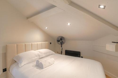 - une chambre avec un lit blanc et un ventilateur dans l'établissement Appartement contemporain au calme, Ecully, à Écully