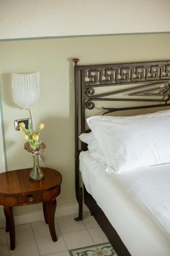 a bedroom with a bed and a table with a vase of flowers at Classique in Lazise