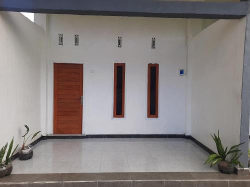 a white room with a door and a tile floor at Ayunda Stay & Hostel in Airsatang
