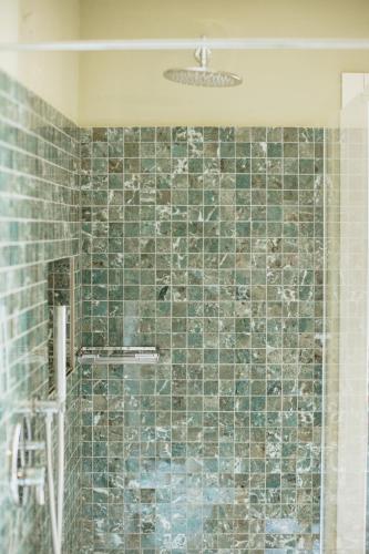 a bathroom with a shower with green tiles at Classique in Lazise