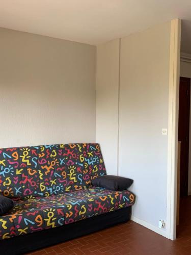 - un canapé dans le salon avec une couverture colorée dans l'établissement Spacious studio of 40 m2 with balcony in Fréjus, à Fréjus