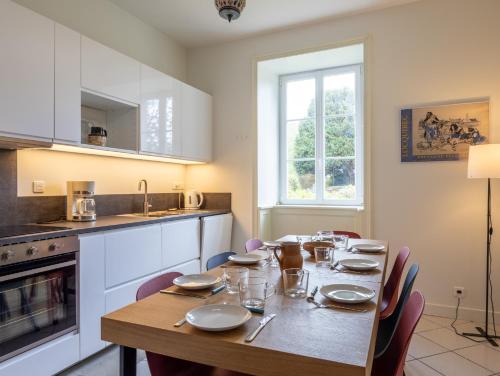 une salle à manger avec une table et une cuisine dans l'établissement Maison au cœur de Locquirec, à Locquirec