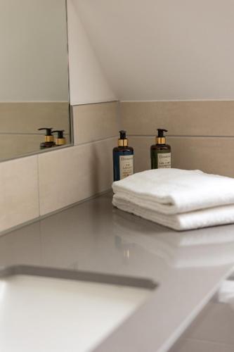 a room with two bottles of towels and a mirror at Restaurant und Hotel Alte Schule Fürstenhagen in Fürstenhagen