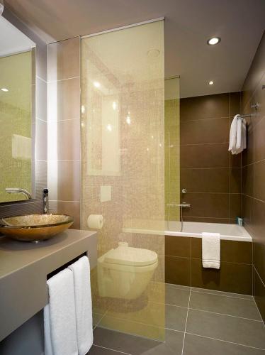 a bathroom with a sink and a toilet and a tub at INNSiDE by Meliá Prague Old Town in Prague