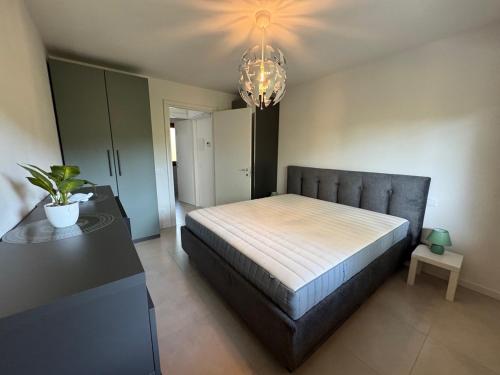 a bedroom with a large bed and a chandelier at Casabianca Resort Villas in Lignano Sabbiadoro