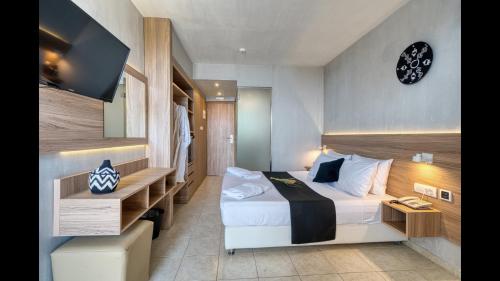 a hotel room with a bed and a flat screen tv at Black & White Resort in Xylokastro