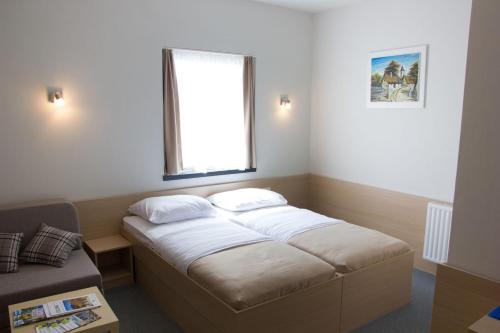 Hotel Lika Jug في Brinje: سرير في غرفة صغيرة مع نافذة