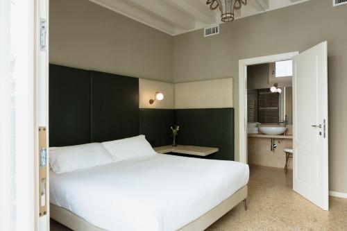 a bedroom with a white bed and a bathroom at Classique in Lazise