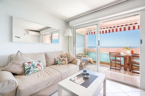 un salon avec un canapé et une vue sur l'océan dans l'établissement BelleVue Palace, à Menton