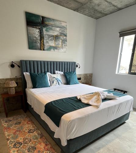 a bedroom with a large bed with blue pillows at Boutique Hotel Luz da Lua in Ponta do Sol