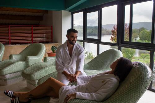 a man and a woman sitting on a couch at Laias Caldaria hotel y Balneario in Laias