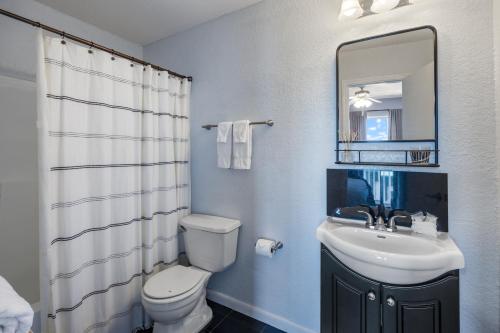 a bathroom with a sink and a toilet and a mirror at Kate's Place - 13554 Perdido Key Drive in Pensacola