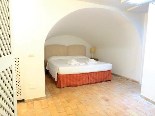 Un dormitorio con una cama en forma de arco. en La Casa del Faro, en Porto Ercole