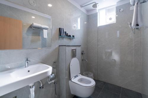 a bathroom with a white toilet and a sink at Serene Resort Hyderabad in Shamshabad