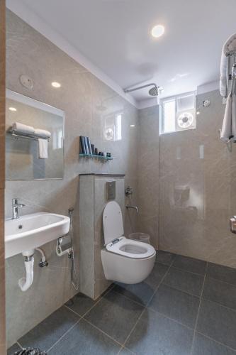 a bathroom with a toilet and a sink at Serene Resort Hyderabad in Shamshabad