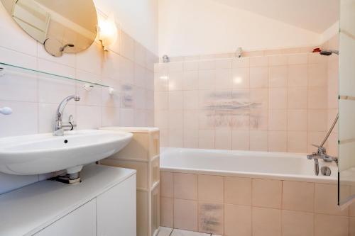 une salle de bain avec un lavabo et une baignoire dans l'établissement Les Hortensias, à Hillion