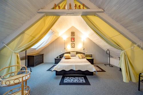 une chambre avec un lit dans un grenier dans l'établissement Les Hortensias, à Hillion