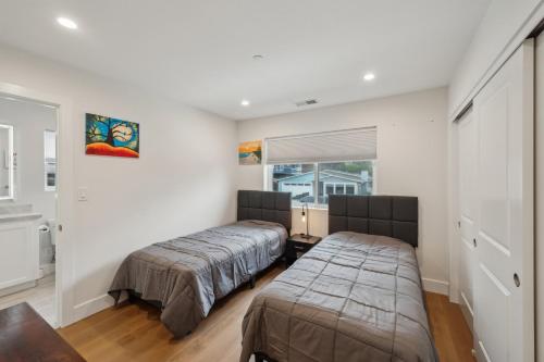 a bedroom with two beds and a window at Panoramic Ocean Views Modern Coastal Escape home in El Granada