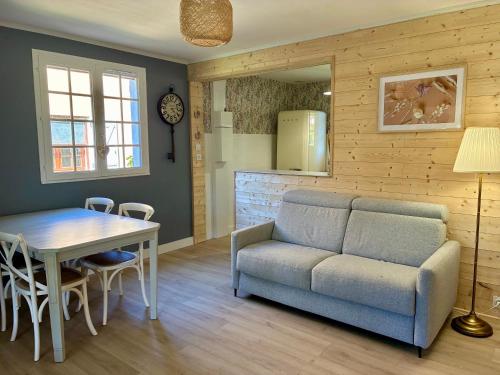 un salon avec un canapé et une table dans l'établissement La villa Les Rosiers en Cévennes, à Saint-Martial