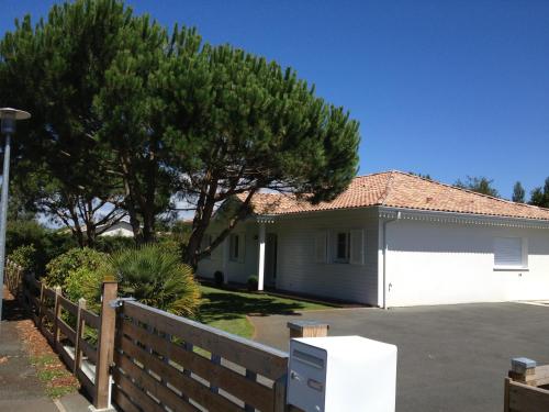 une maison blanche avec une clôture et un arbre dans l'établissement Villa du paradis des canards, à La Teste-de-Buch