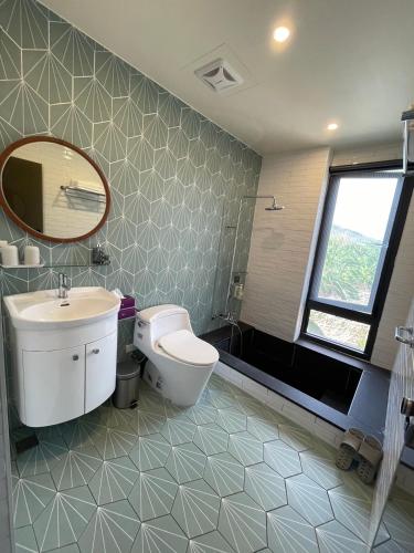 a bathroom with a toilet and a sink and a mirror at Piano Hotel in Xiaoliuqiu