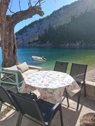 a table and chairs sitting next to a body of water at Apartment Maestrol in Zastražišće