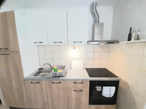 a small kitchen with a sink and a stove at Apartment Maestrol in Zastražišće