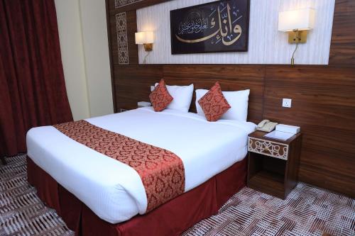 a hotel room with a bed and a telephone at Abraj Al Tayseer Tuwa Hotel in Makkah