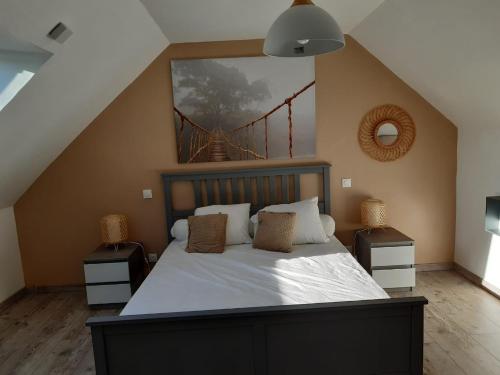 une chambre avec un lit avec un tableau sur le mur dans l'établissement Maison prés des plages, à Névez