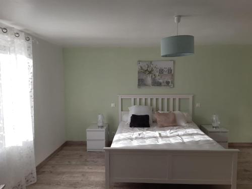 une chambre avec un grand lit blanc avec des oreillers dans l'établissement Maison prés des plages, à Névez