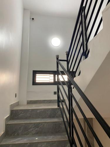 a staircase in a house with a stair railing at Chambre meublée avec balcon 3S Ngor Almadies Dakar in Dakan