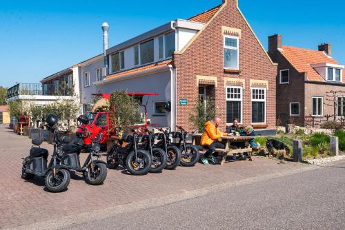 a row of motorcycles parked on the side of a street at Hotel-Pension Ouddorp in Ouddorp