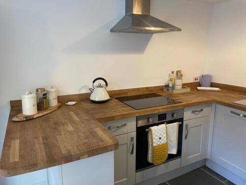 a kitchen with a counter top with a stove top oven at Gardeners Cottage in Mudford