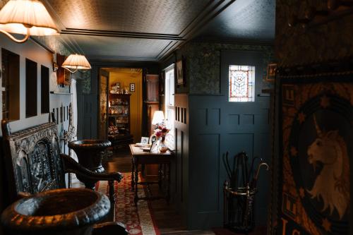 un couloir avec une pièce aux murs bleus et une table dans l'établissement Sheddington Manor - 2 Bedroom Guest House & Cinema, à Belfast