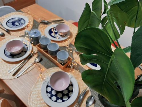 a table with plates and cups and a plant on it at KUROFUNE久我山ハウス,shibuya 13min,Kichijoji3min in Kugayama