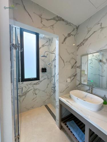 a bathroom with a sink and a glass shower at Greenlife Village Phú Quốc in Phu Quoc