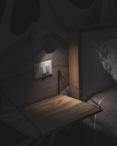 a lightswitch on a wall next to a bed at Nausicaa Guesthouse in Marsala