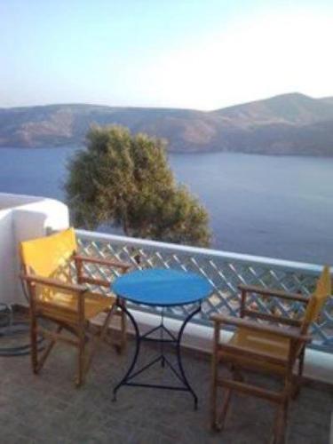 two chairs and a table on a balcony overlooking a lake at Asvestoti blue ciel light 2 in Pera Gyalos