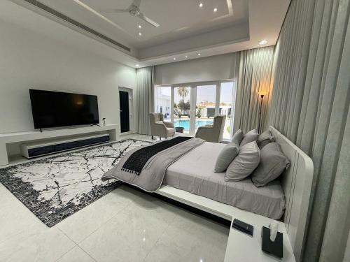 a large bedroom with a large bed and a television at Radiance Holiday Resort Muscat in Seeb
