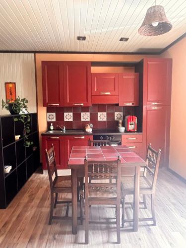 a kitchen with red cabinets and a table with chairs at B&B Camelia in Camugnano