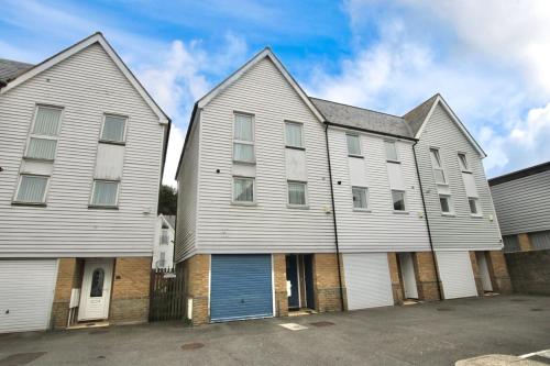a large white house with a blue garage at The Dover House with river and Castle views in Dover